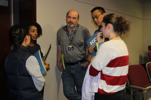 A group of people standing in a group talking