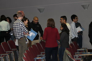 Audience members in an auditorima standing in groups talking