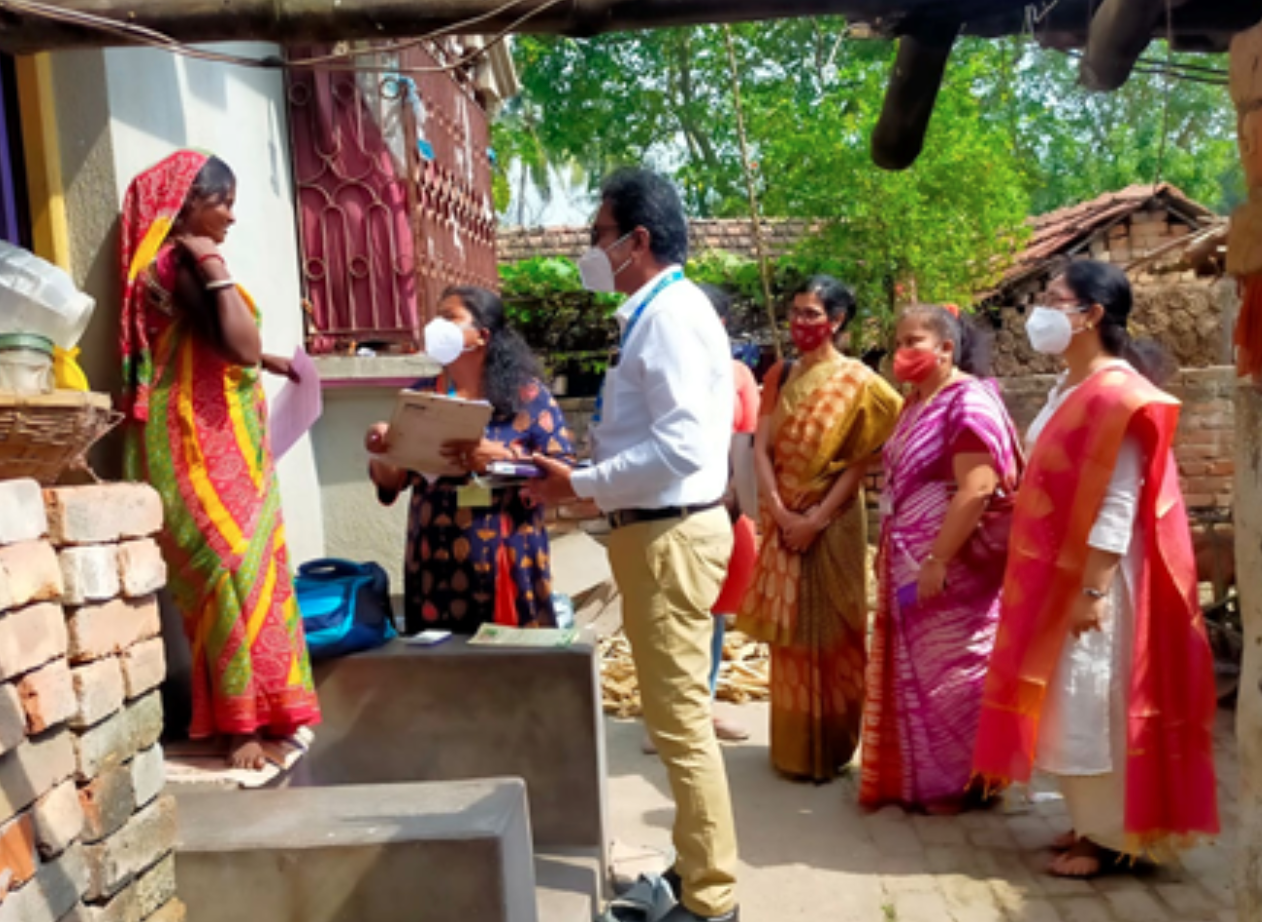 Health workers talk with woman