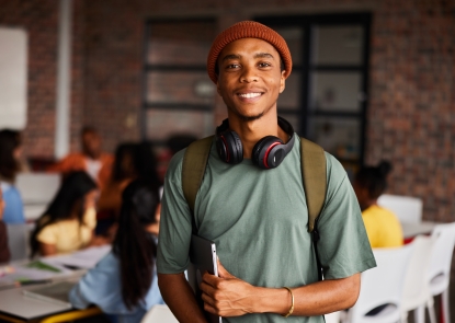 Young man holding laptop and smiling