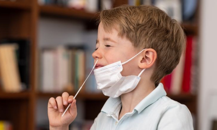 A young boy prepares to take a COVID-19 test