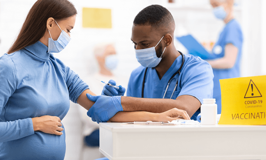 A pregnant woman gets a vaccine from a health care worker