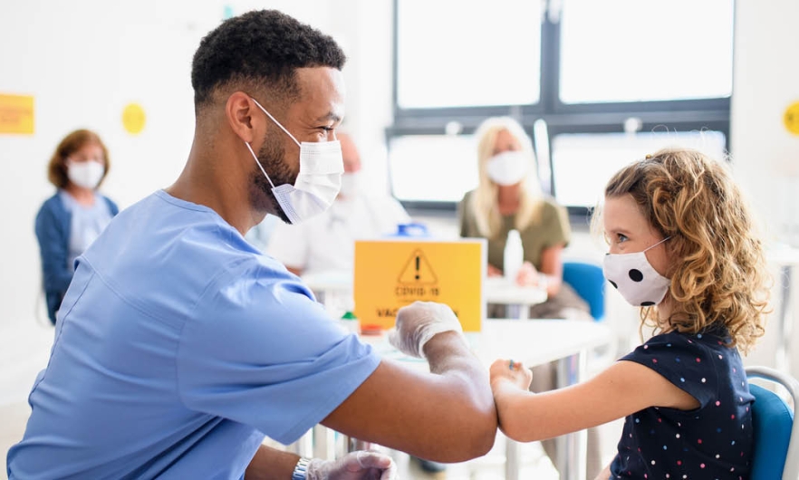 Doctor touching elbows with young patient