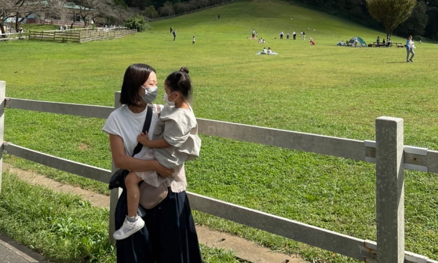 mother holding her child both wearing masks