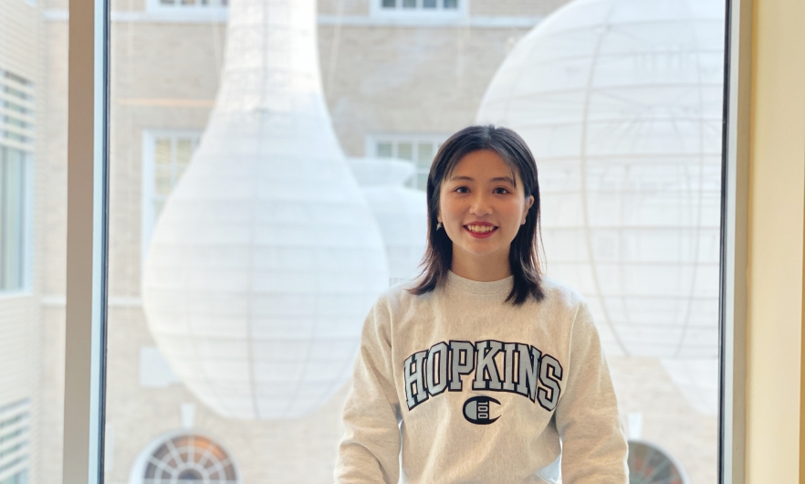 Young woman in Hopkins shirt in front of a window