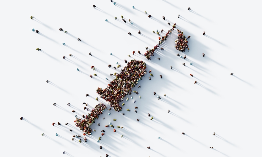 Aerial view of thousands of people forming shape of an injector