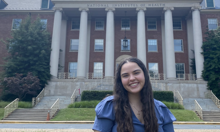 young woman standing in front of NIH building
