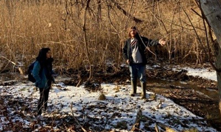 students discussing project in a snowy patch of ground