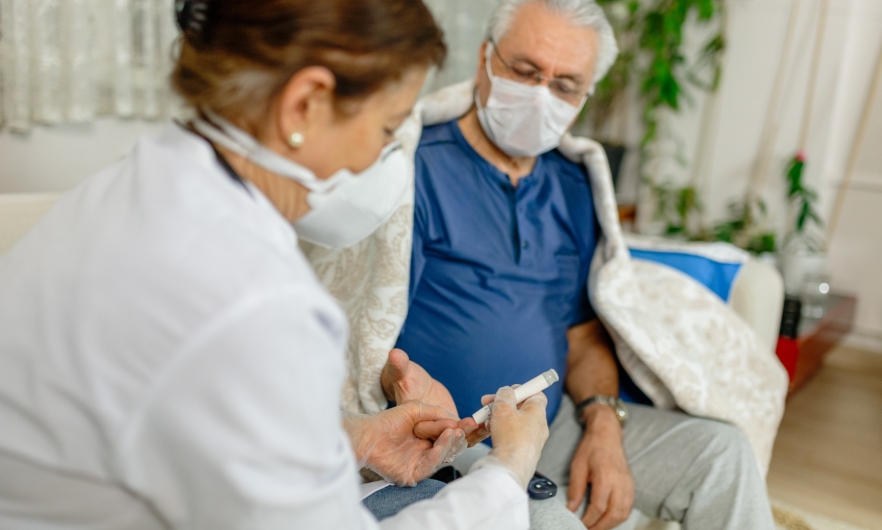 Doctor pricking patient's finger for diabetes test