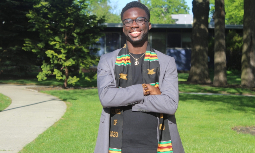 African American male smiling, standing outdoors 