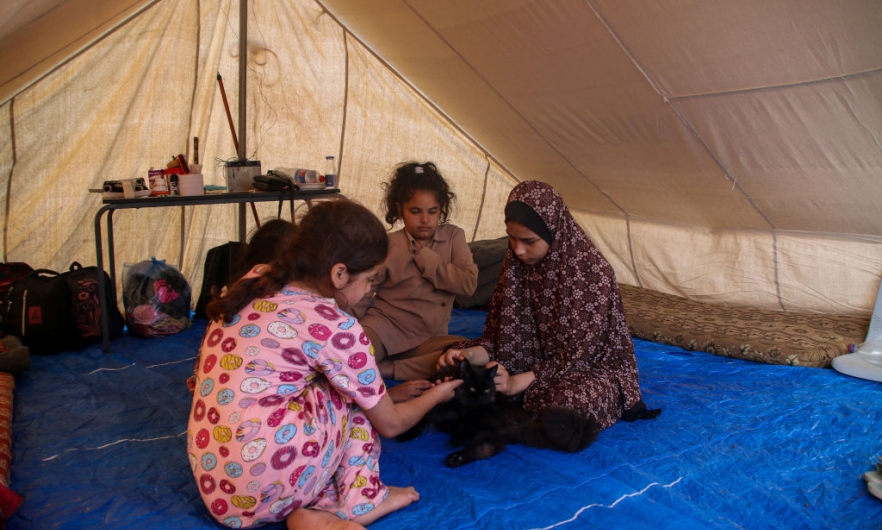 Palestinian children rest in a refugee tent along the Gaza Strip