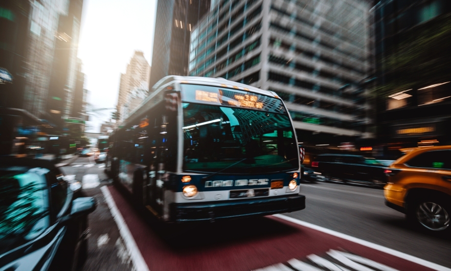 Bus approaching in bus lane on busy city street