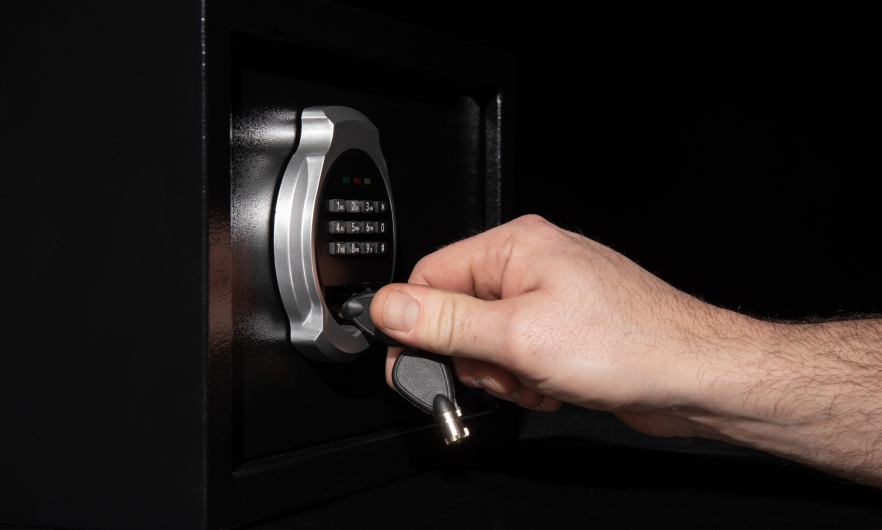 A man's hand closes a safe