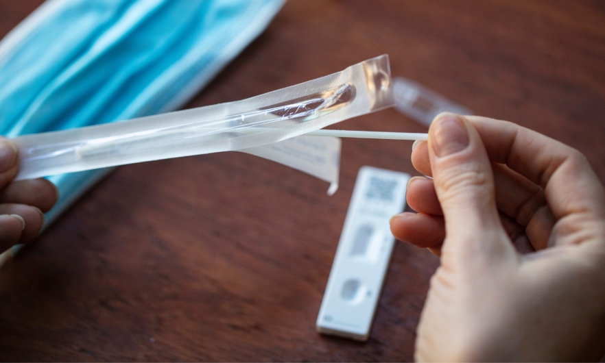 Unwrapping a swab to take a home covid test