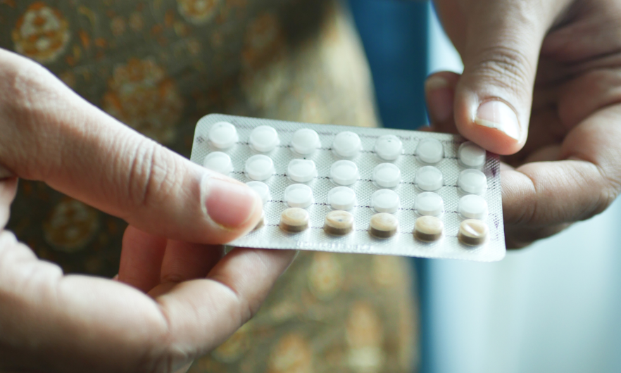 A person holding a packet of birth control pills