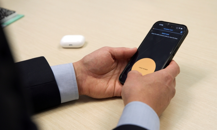 Using the Hearing Number app A person takes a hearing test on their smartphone
