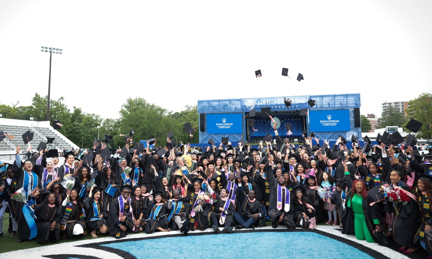 graduates toss caps in air