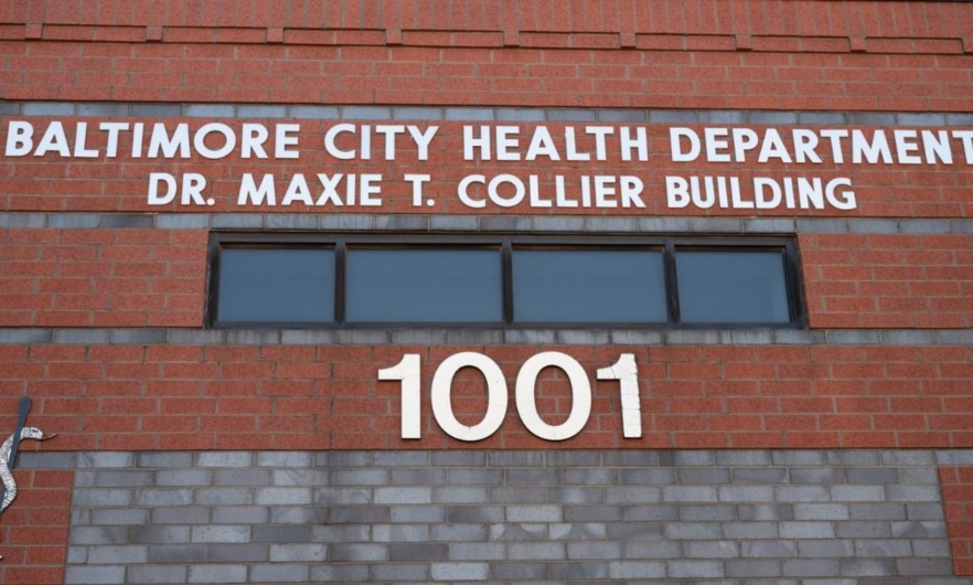 A brick building with white letters that read Baltimore City Health Department