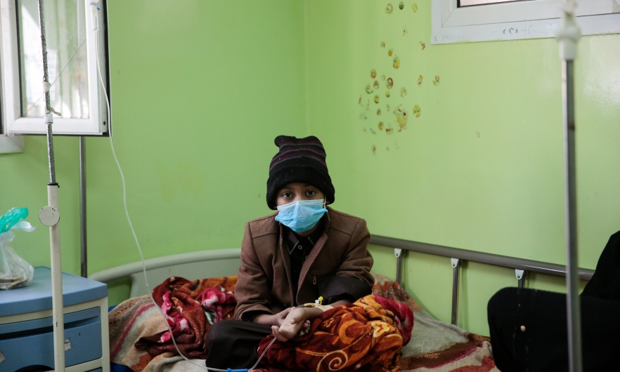 A boy who has cancer, sits on a bed as he receives treatment at the Oncology Centre in Sanaa, Yemen.