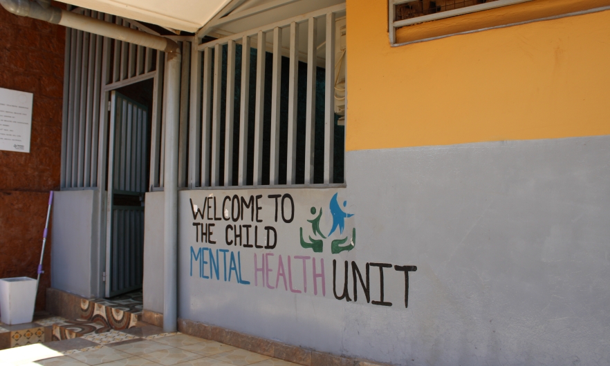 Yellow and gray building with the words &quot;welcome to the mental health unit&quot; painted on them.