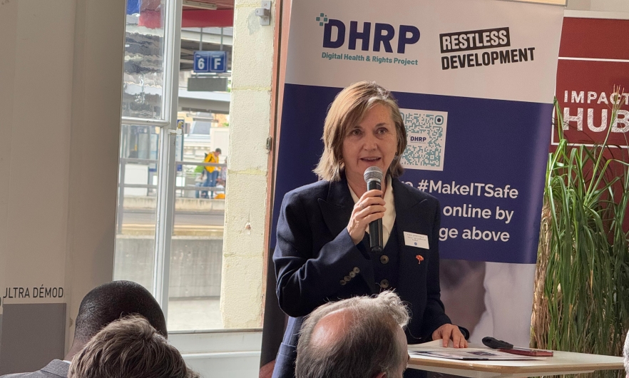 Photo of Professor Meg Davis holding a microphone and speaking before an audience for a sidebar event at the World Health Assembly.