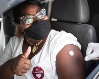 A woman gives a thumbs up after receiving a COVID-19 vaccine