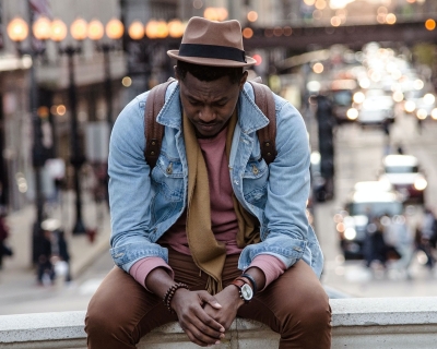 african american man looking down with cityscape in the background