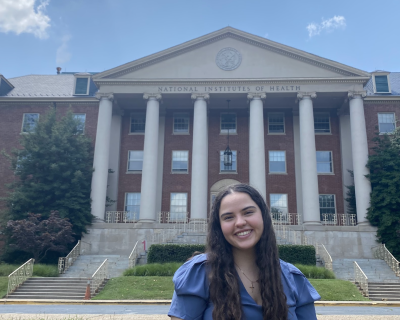 young woman standing in front of NIH building