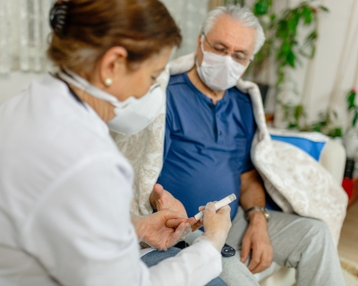 Doctor pricking patient's finger for diabetes test