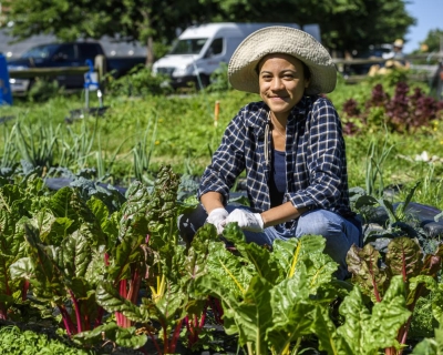 Young woman smiling in a community garden