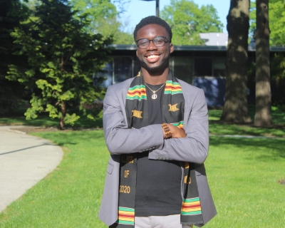 African American male smiling, standing outdoors 