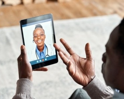 Patient holding tablet speaking with doctor over videochat