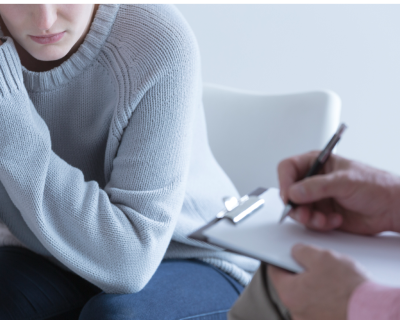 photo of woman talking to someone with clipboard