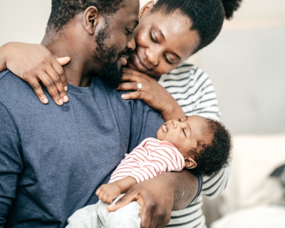 Two young parents hold their infant