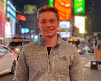 Young man standing outside on busy street