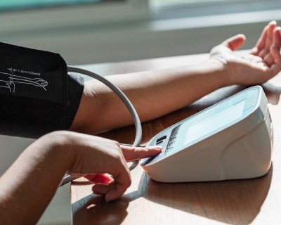 Image of person checking their blood pressure with device