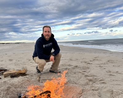 man kneeling on beach
