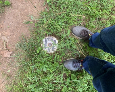 image taken from above of two legs and feed near a gas pipeline cover