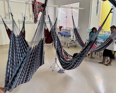 Yanomami Indigenous people rest in traditional blue and white hammocks used in lieu of hospital beds.