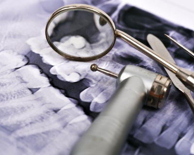 Stock photo of dentist tools on top of xray of teeth