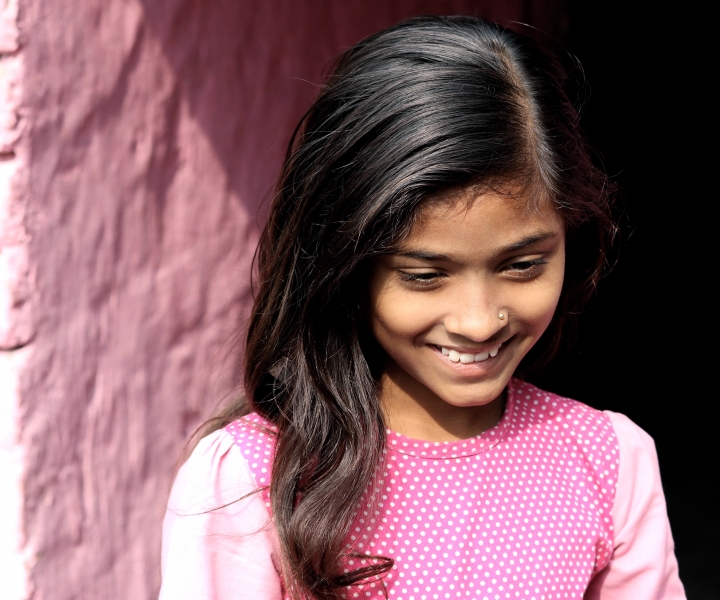 young girl looking down and smiling
