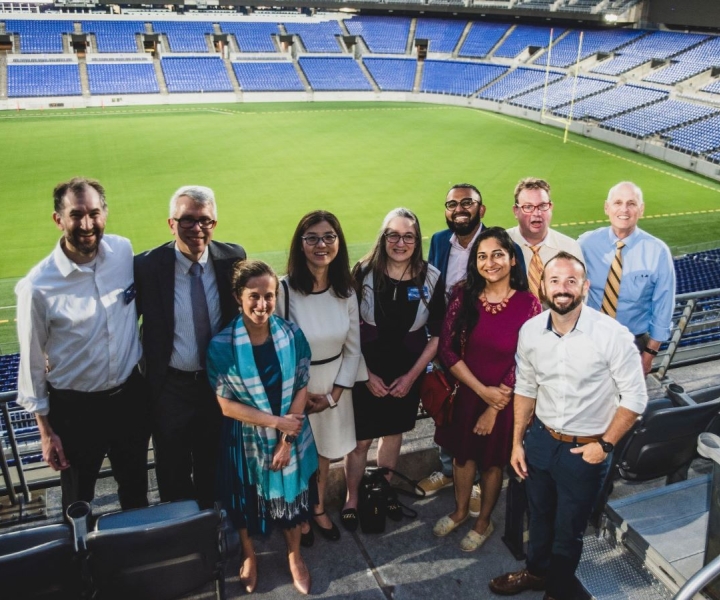 Biostatistics faculty standing inside Raven’s Stadium in Baltimore (L-R) Michael Rosenblum, Andre Hackman, Elizabeth Stuart, Ni Zhao, Karen Bandeen-Roche, Abhirup Datta, Debashree Ray, John McGready, John Muschelli, and Scott Zeger