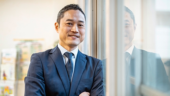 asian man standing, smiling