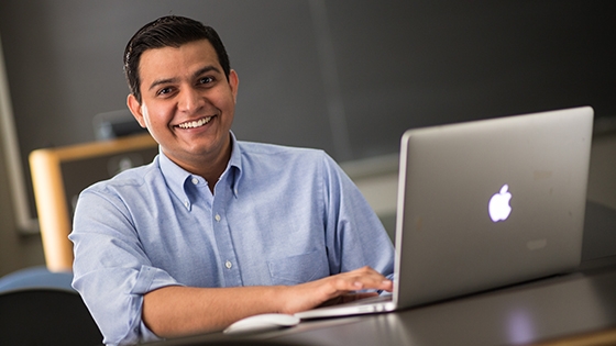 student working on their laptop smiling