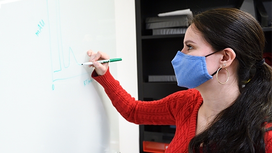 student writing on a whiteboard