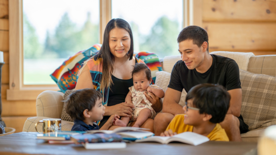 family sitting on a couch reading books together