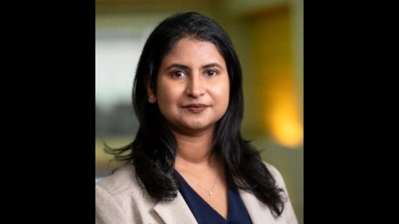 A headshot of a woman wearing a suit jacket as she smiles