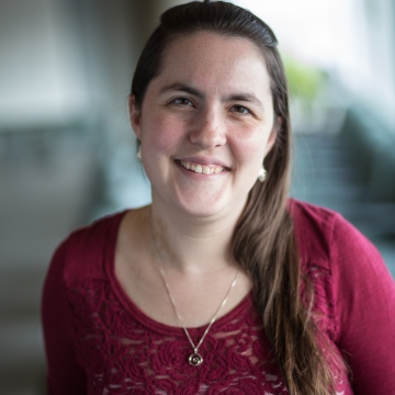 A Woman with long dark brown hair and a maroon shirt