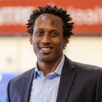 A headshot of a man smiling