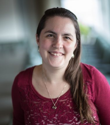 A Woman with long dark brown hair and a maroon shirt